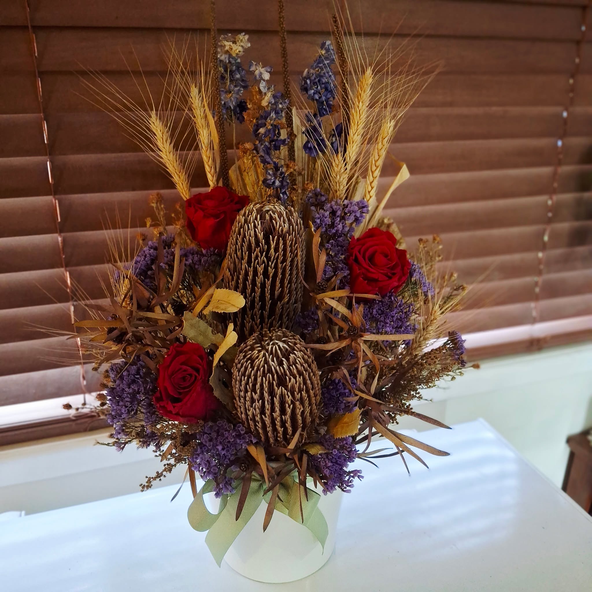 Loved creating this dried arrangement for a birthday, with its mix of textures and colours. We used preserved rich red roses, rustic wheat, native banksias, leucadendron, soft purple foliage flowers, accented with daisy foliage.

Wishing the birthday lady the happiest of birthdays and a year full of love, laughter and little moments of peace. 💛🌿💐🥳

 #giftideas #flowersandgifts #birthdaygift #driedflowers #simplethingsinlife❤️